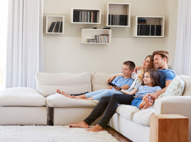 a family sitting on a living room couch enjoying their family and purified air 