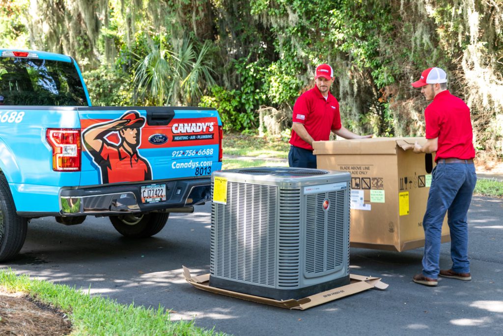 Canady's HVAC technicians removing a new air conditioner from a service truck