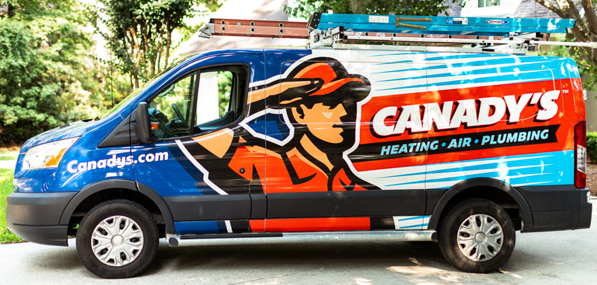 canady's heating air plumbing service vehicle with man standing at attention on side